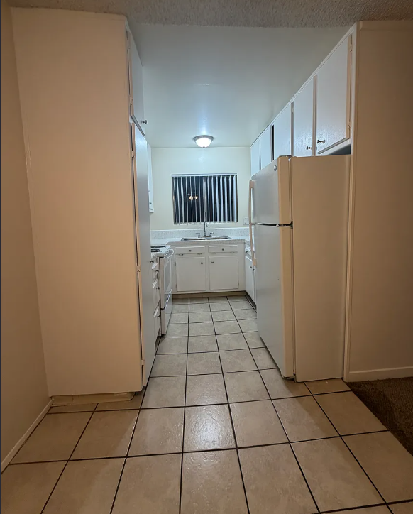 A kitchen with white appliances and white cabinets.